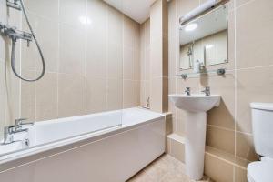 a bathroom with a tub and a sink and a toilet at Avocet Cottage in Brancaster +22 photos