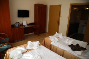 two beds in a hotel room with towels on them at Sanatorium Borkowo in Połczyn-Zdrój