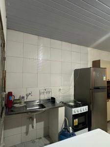 a small kitchen with a sink and a refrigerator at Aparentemente Bem Localizado in Boa Vista