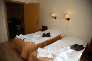 two beds in a hotel room with towels on them at Sanatorium Borkowo in Połczyn-Zdrój