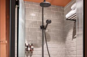 een douche in een badkamer met een witte tegelmuur bij grey l studio apartments Downtown Cairo Bidair House in Caïro +54 foto's