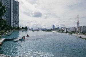 dos personas nadando en un río en una ciudad en Modern KL City M vertica condo near MRT, TRX & Sunway Velocity, infinity pool & Parking, en Kuala Lumpur