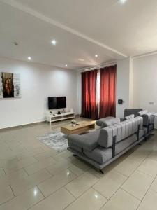 een woonkamer met een bank en een tv bij Sunny's Place Luxury Apartments in Accra +18 foto's