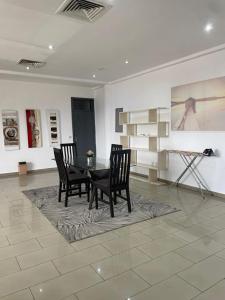 een eetkamer met een tafel en stoelen en schilderijen bij Sunny's Place Luxury Apartments in Accra