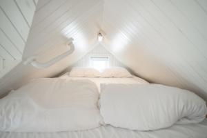 a bed with two pillows in a small room at Olenilsøya Mini Villa in Reine