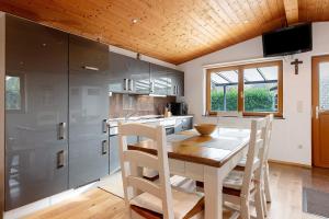 una cocina con mesa y sillas de madera y una cocina con encimera en Ferienhaus Weichart, en Sulzburg 11 fotos más
