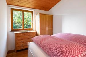 1 dormitorio con cama, ventana y vestidor en Ferienhaus Weichart, en Sulzburg