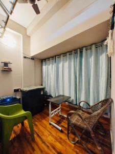 a room with a table and chairs and a window at The Mishing Room in Guwahati