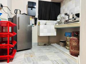 a kitchen with a stainless steel refrigerator and red shelves at The Mishing Room in Guwahati