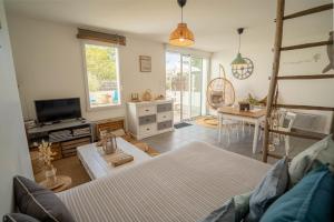 Μια τηλεόραση ή/και κέντρο ψυχαγωγίας στο Maison avec fauteuil suspendu et lit de jour près de la mer en Vendée