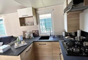 una cocina con fregadero y estufa horno superior en Po - Design et confort - 3 ch, 2 sdb, proche plages, gares et aéroport, en Lattes