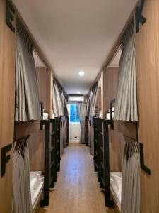 a long hallway with bunk beds in a room at Ralph Poshtel Sukhumvit in Bangkok