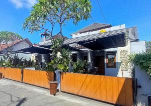 a house with an orange fence in front of it at Andewi Homestay RedPartner - Minimum Stay 30 Nights in Pesanggaran