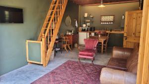 ein Wohnzimmer mit einer Treppe und einem Tisch und Stühlen in der Unterkunft Stone Cottage With Sea Views in Wilderness