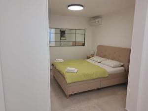 a bedroom with a bed with a yellow blanket at Seafront Suites Maja in Vis