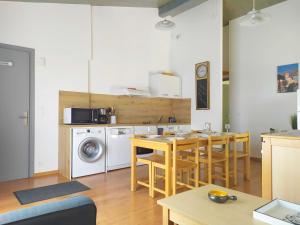 een keuken met een tafel en stoelen en een wasmachine bij L'ourmeou in Coursegoules