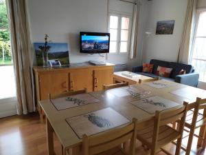 een woonkamer met een eettafel en een televisie bij L'ourmeou in Coursegoules