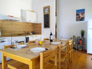een keuken met een tafel met stoelen en een klok bij L'ourmeou in Coursegoules