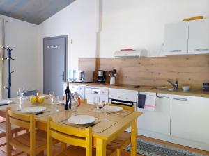 a kitchen with a wooden table with chairs and a dining room at L'ourmeou in Coursegoules +34 photos