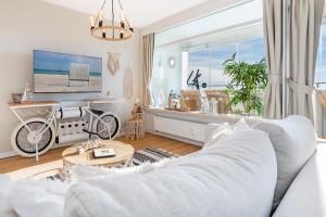 uma sala de estar com um sofá branco e uma bicicleta em Panoramic Loft mit Meerblick em Sierksdorf