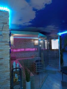 Un baño con luces moradas en una pared de ladrillo. en Ferienwohnung Maaridyll In Schalkenmehren, en Schalkenmehren