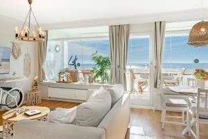uma sala de estar com um sofá e uma mesa e uma sala de jantar em Panoramic Loft mit Meerblick em Sierksdorf mais 22 fotografias