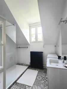 een witte keuken met een wastafel en een raam bij Le B & W in Le Mans