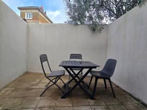 een picknicktafel en twee stoelen voor een hek bij Le B & W in Le Mans