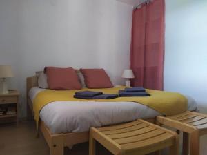 a bedroom with a bed with yellow sheets and red pillows at Le cheiron in Coursegoules
