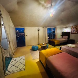 a bedroom with two beds and a chandelier at Dream Luxury Majestic Camp in Merzouga