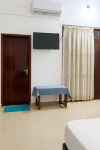 una habitación con una puerta y un banco junto a una puerta en Mirissa Eye Beach Hotel and Restaurant, en Mirissa