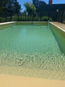 a large pool of water with a tennis court at Icalma De La Sierra in Tandil