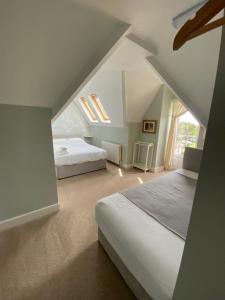 - une chambre mansardée avec 2 lits et une fenêtre dans l'établissement Florence House in Sussex, à Seaford