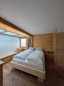 Un dormitorio con una cama en una habitación de madera. en Appt de charme dans chalet - cosy & nature, en Villars-sur-Ollon