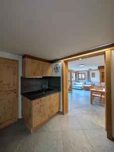 Una cocina con fregadero y una sala de estar. en Appt de charme dans chalet - cosy & nature, en Villars-sur-Ollon