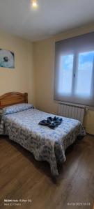 a bedroom with a bed and a large window at Hostal Hotel EL Chato in El Barraco