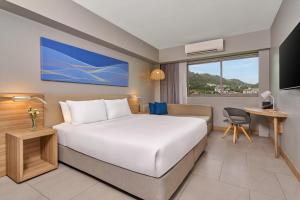 una habitación de hotel con una cama y un escritorio en Mercure Phuket Patong Journeyhub, en Patong Beach 70 fotos más