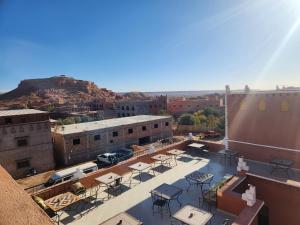 a rooftop patio with tables and chairs on a building at La Rose De Sable in Aït Ben Haddou