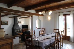 a dining room with a table and a fireplace at La bastide du rousset in Ascros