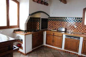 a kitchen with wooden cabinets and a counter top at La bastide du rousset in Ascros