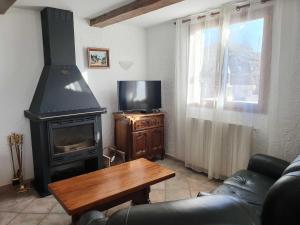a living room with a stove and a tv at La bastide du rousset in Ascros +21 photos