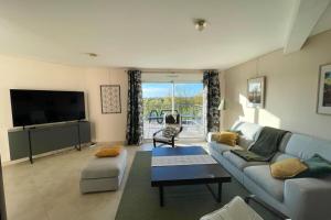 Una televisión o centro de entretenimiento en Le Clos des Cigognes - Architect-designed house near Omaha Beach