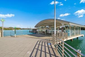 ein Dock mit einem Gebäude auf dem Wasser in der Unterkunft Lumière Riverside One Bedroom Apartment In Ryde With Queen Bed and Free Parking Close to Train & Ferry & Cafes in Sydney + 4 Fotos