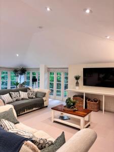 AldbourneにあるThe Baydon House Luxury Studioのソファとテレビのあるリビングルーム