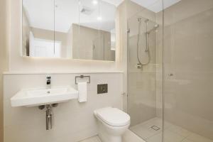 ein Badezimmer mit Toilette, Waschbecken und Dusche in der Unterkunft Lumière Riverside One Bedroom Apartment In Ryde With Queen Bed and Free Parking Close to Train & Ferry & Cafes in Sydney