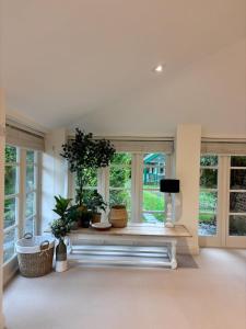 AldbourneにあるThe Baydon House Luxury Studioの窓と植物のあるベンチのあるリビングルーム