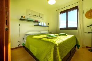 Un dormitorio con una cama con una manta verde encima. en Terrazza Catabbio, en Catabbio 23 fotos más