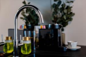 a kitchen counter with a faucet and two glasses of beer at Żurawia Mini Apartments by Sofija in Warsaw +96 photos