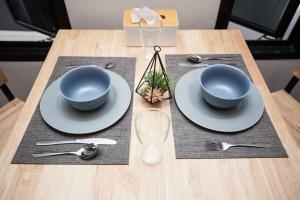 une table avec deux bols bleus et des assiettes dessus dans l'établissement comfortable BAMBOO houses, à Ban Thalat Choeng Thale