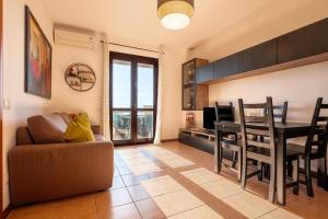 Una sala de estar con un sofá y una mesa con televisión. en Terrazza Catabbio, en Catabbio